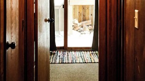 A wooden hallway leading to a glass door with a view of an outdoor area. - Slope Side Winter Villa I Alpen Villas at Powderhorn Mountain (Bessemer Township)