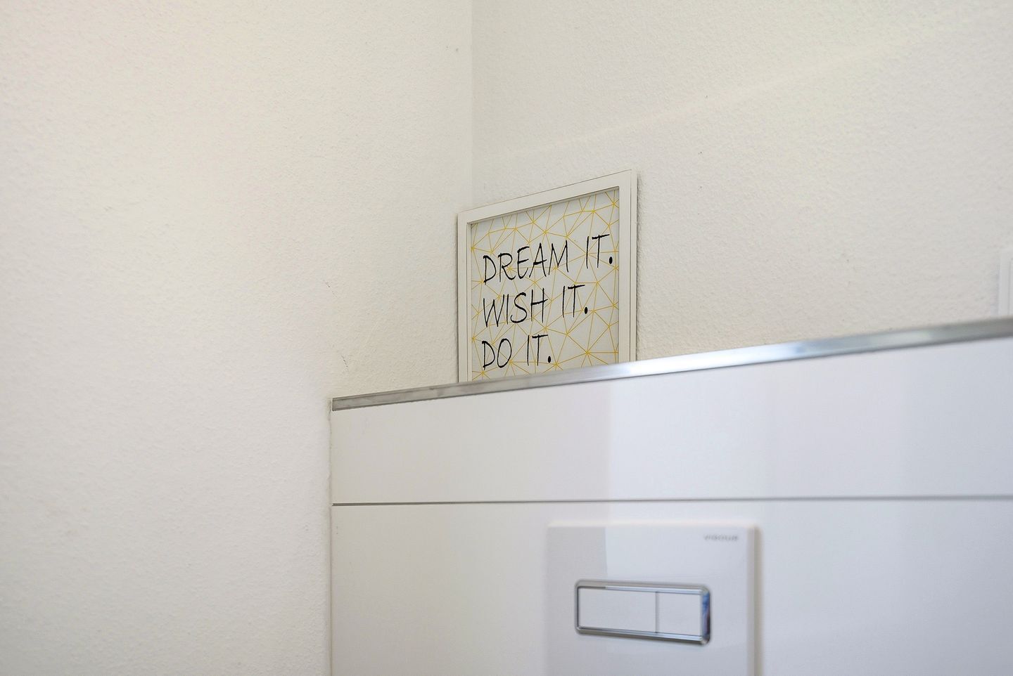 En väggmonterad skylt med motiverande text och en ljusströmbrytare under.