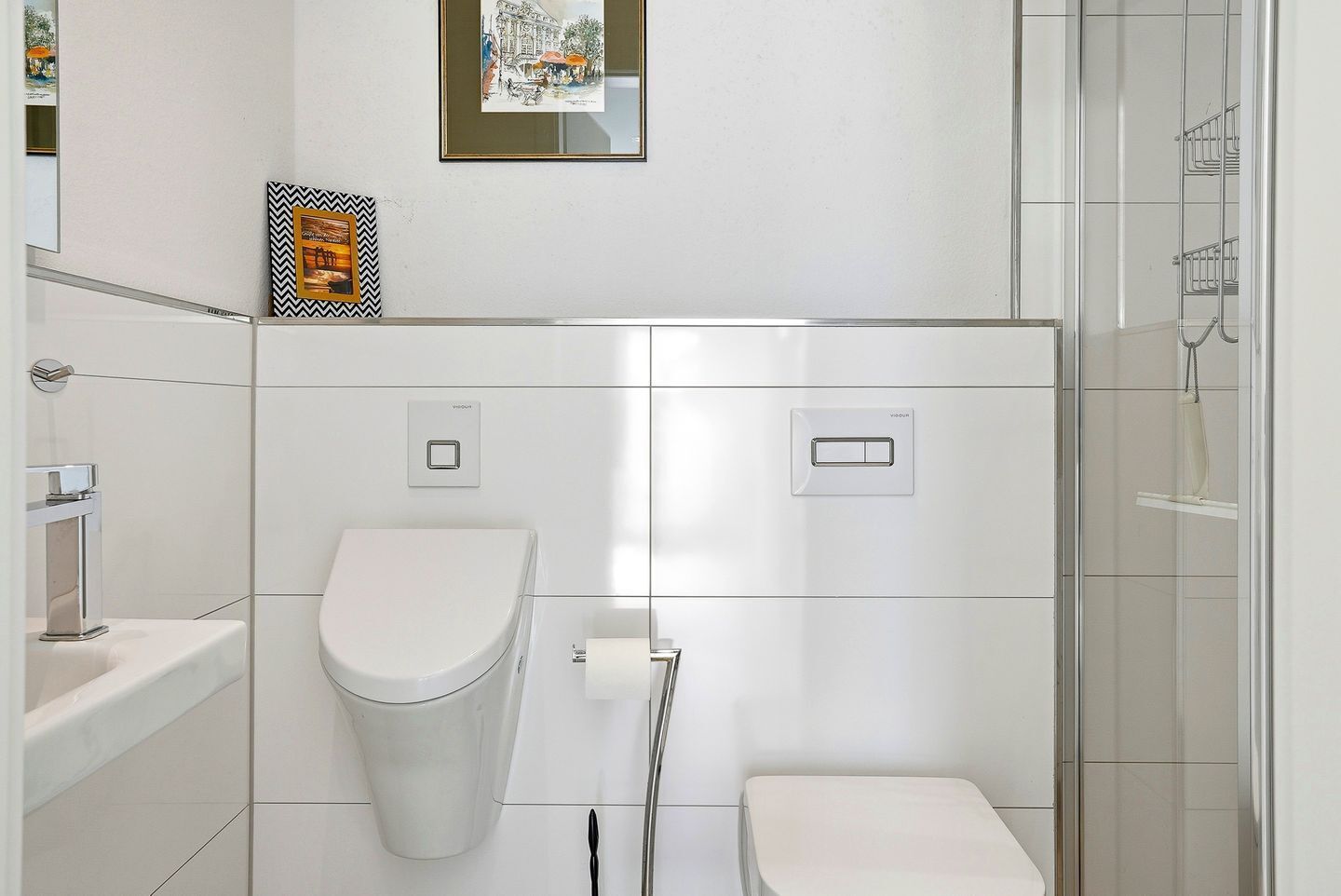 A modern bathroom with a toilet, bidet, and shower.
