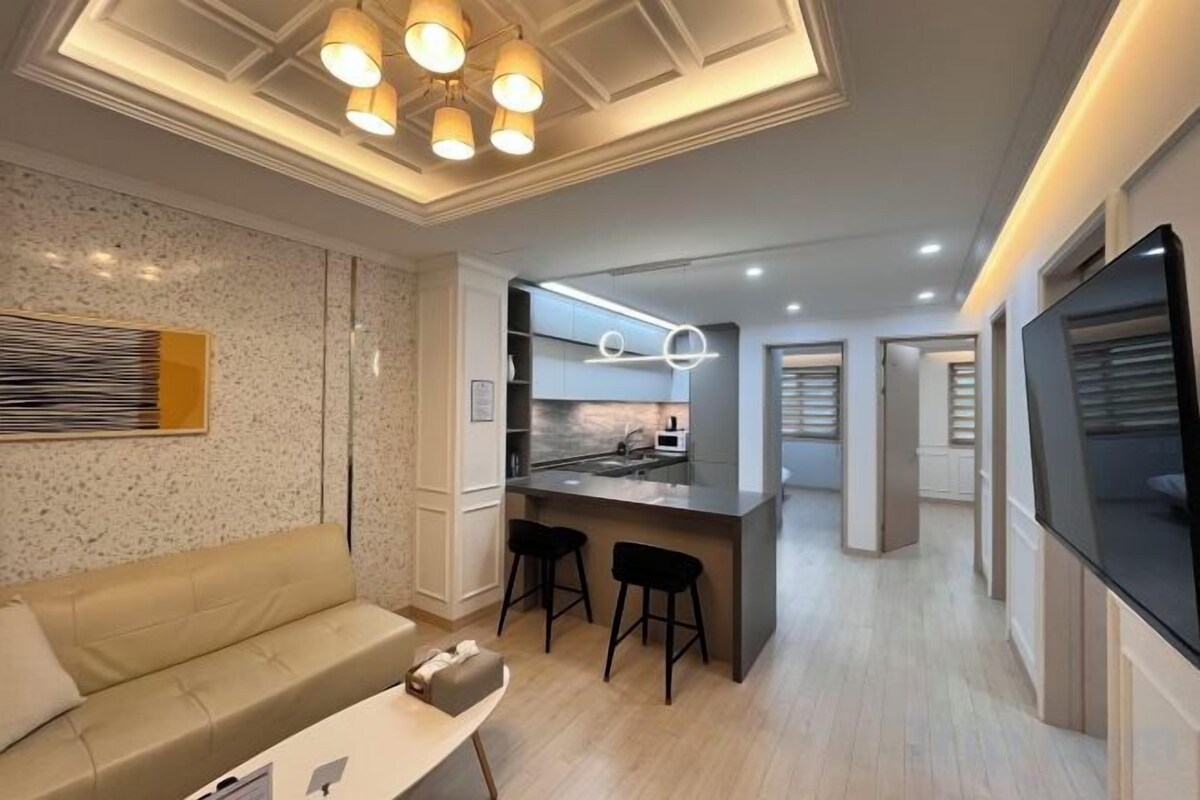 Un interior moderno con cocina, zona de comedor y sala de estar con sofá y mesa de centro.