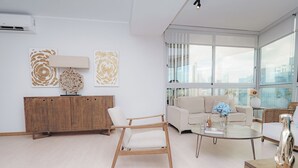 A modern living room with a sofa, armchair, coffee table, and decorative items. - Luxury 2BR Cityview apt, parking and balcony (Panamá)