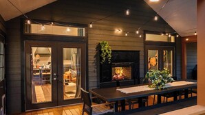 Un patio exterior con mesa, sillas y chimenea.