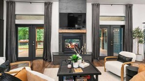Una sala de estar moderna con chimenea, asientos cómodos y vistas al exterior.