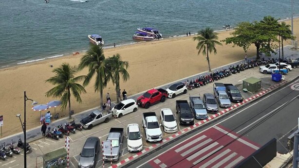 A beachside view with a parking area, beach, and a distant city skyline. - Cloudotel Walking Street Pattaya  (Pattaya)