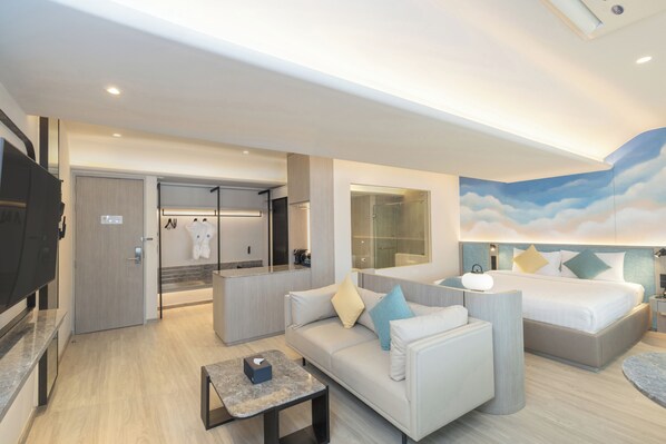 A modern hotel room with a sofa, a bed, a TV, a bathroom, and a large window. - Cloudotel Walking Street Pattaya  (Pattaya)