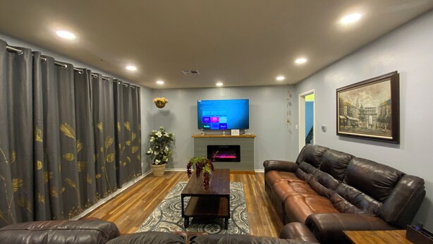 A living room with a sofa, a coffee table, a TV, and a fireplace.