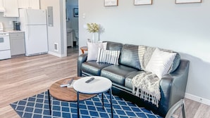 Un salon moderne avec un canapé en cuir, une table basse et un tapis.