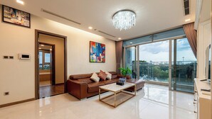 A modern living room with a brown leather sofa, a glass coffee table, and a large window offering a city view. - Apartment in Landmark-Vinhome.CTP by Yen (Ho Chi Minh City)