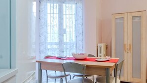 A dining area with a table, chairs, a bowl, and a cabinet. - GuestHost - La Mole Apartment with Balcony (Torino)