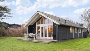 A modern house with a large porch, a covered patio, and a view of the surrounding area.