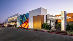 Un bâtiment moderne doté d’une façade géométrique aux couleurs vives, d’une entrée en verre et d’une enseigne indiquant « PHOLOLIC ».