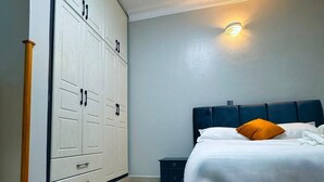 Un dormitorio con cama, armario y mesita de noche.