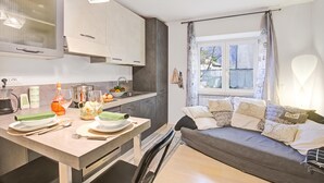 Une cuisine moderne avec un coin repas, un canapé et une fenêtre avec des rideaux.