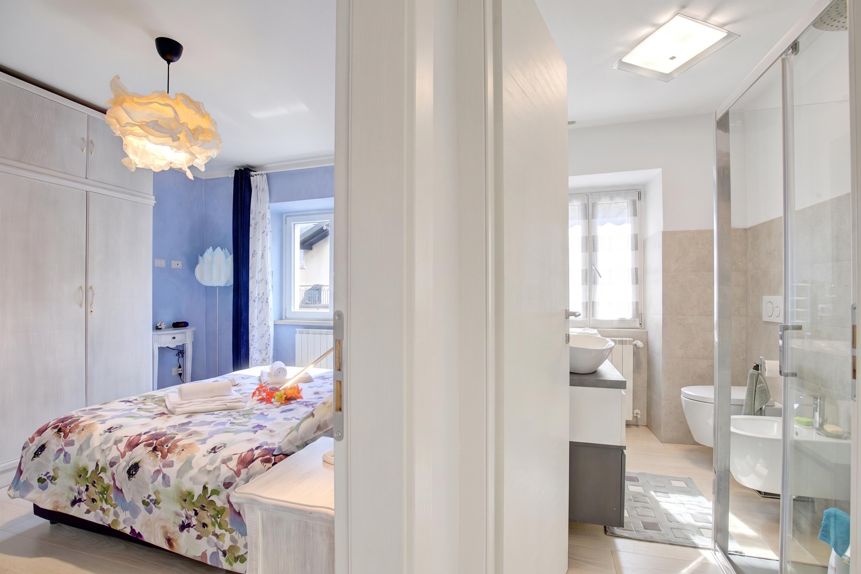 Une chambre à coucher moderne avec un lit, une table de chevet et une salle de bain équipée d’un lavabo et de toilettes.