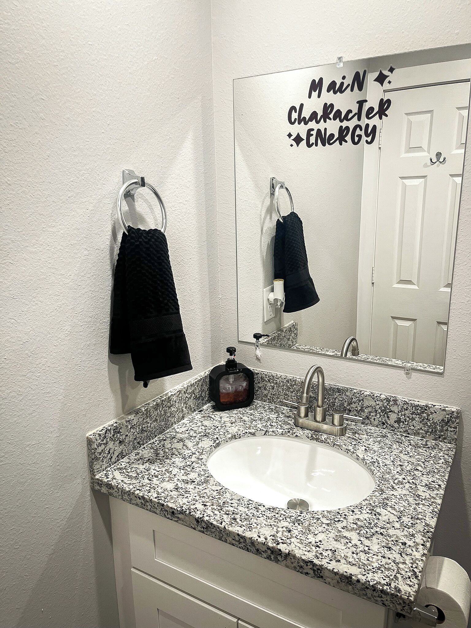 Une salle de bain avec un lavabo en granit, un miroir et un porte-serviettes.