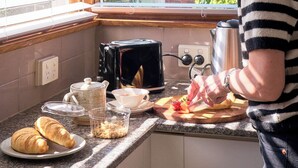 Eine Küche mit Fenster, einem Toaster, einem Wasserkocher und einem Teller mit Croissants.