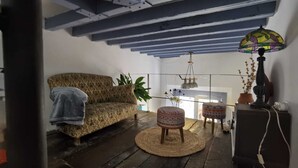 A cozy room with a patterned sofa, a small round table, and a lamp.