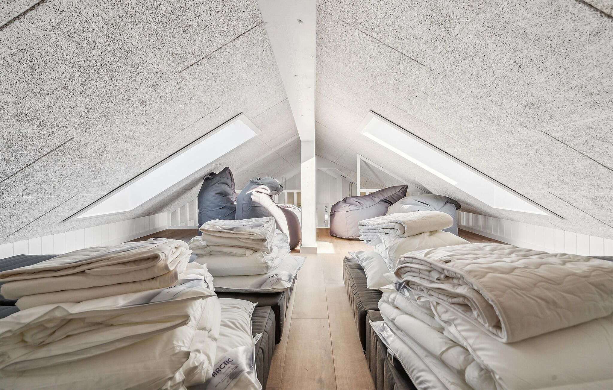 A loft bedroom with high ceilings, sloped ceilings, and skylights.