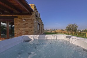 Un bain à remous avec vue sur un bâtiment en briques et un paysage.
