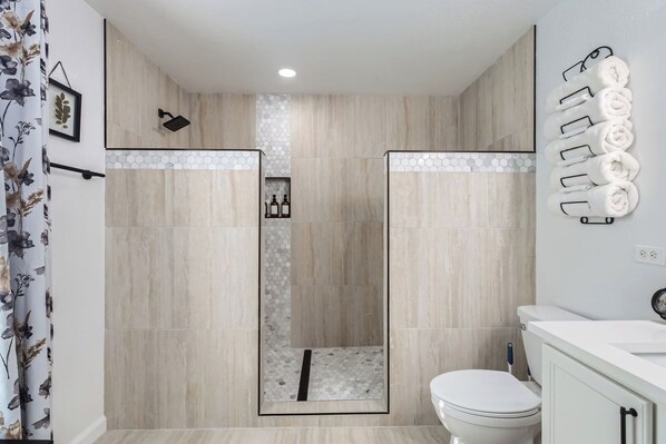 A modern bathroom with a shower area, a toilet, and a sink.