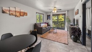 A spacious living area with a sofa, coffee table, and artwork on the wall. - Pet Friendly Flagstaff home Mountain Views &Grill (Flagstaff)