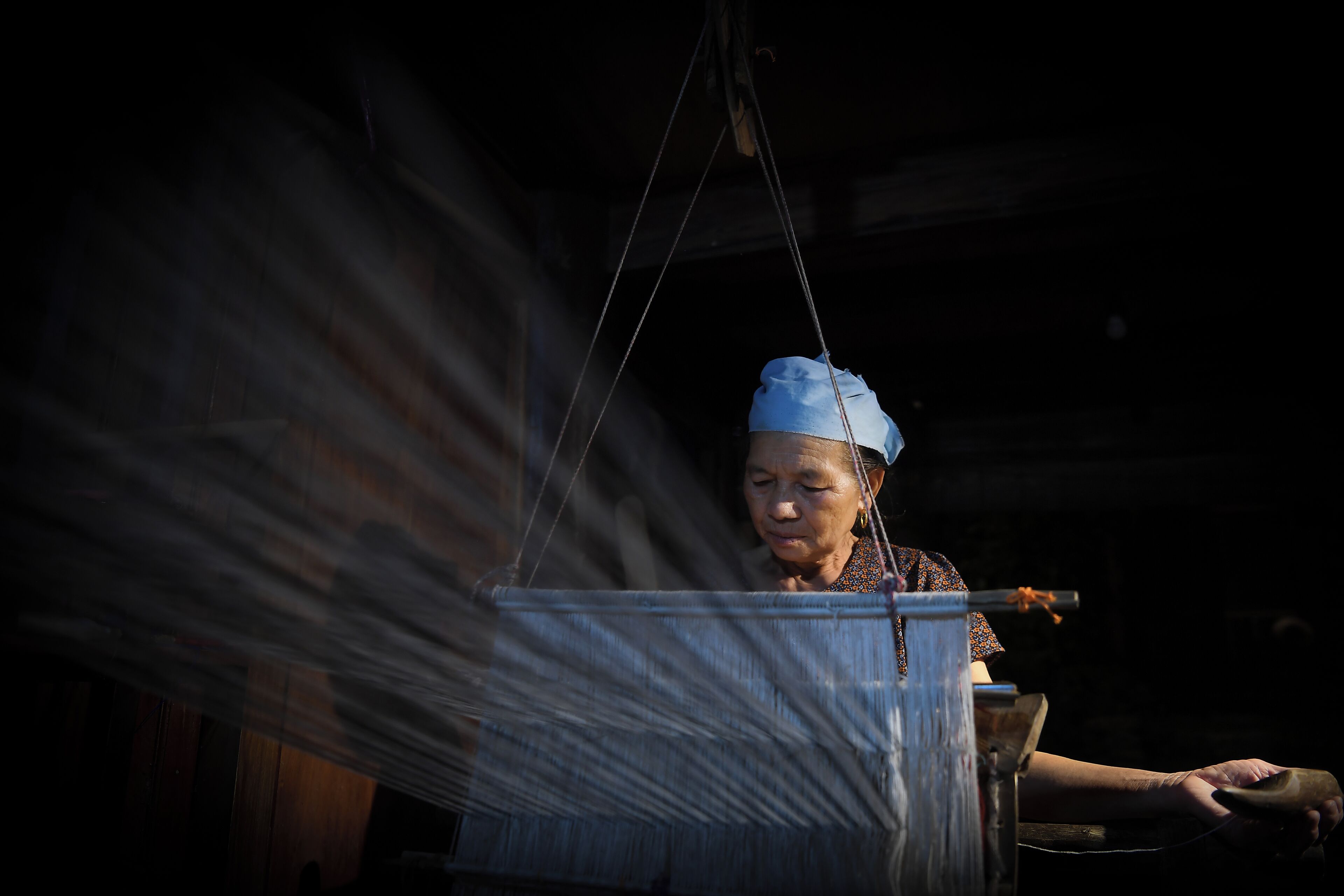 A person working with a large woven basket.