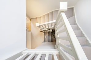 Eine Treppe mit weißen Geländern und einem Teppichbelag.