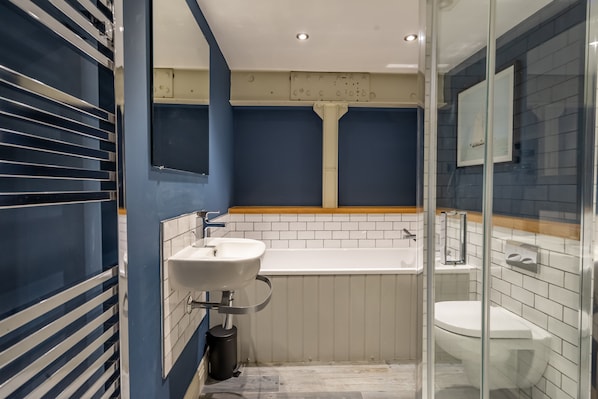 A bathroom with a white sink, a bathtub, and a toilet.
