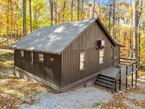 A rustic cabin with a sloped roof, a chimney, and a small porch with steps. - Cozy w/Fire Pit, Grill, Screened Porch & WiFi (Harpers Ferry)