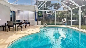 Une piscine intérieure dotée d’un patio couvert, d’un espace détente et offrant une vue sur l’extérieur.