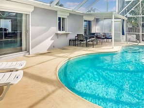 A swimming pool with a sunken seating area, a covered patio with tables and chairs, and a glass-enclosed room. - 3br with Pool Near Golf, Beaches & more (Melbourne)