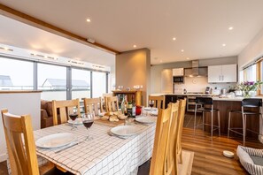 Kitchen and dining table set for eight on the top floor, spacious open-plan self-catering holiday home in Rhosneigr, Anglesey