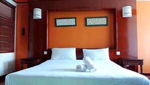 A hotel room with a large bed, two nightstands, and two wall-mounted lamps. - Alpine Premium Water Chalet 2  (Port Dickson)
