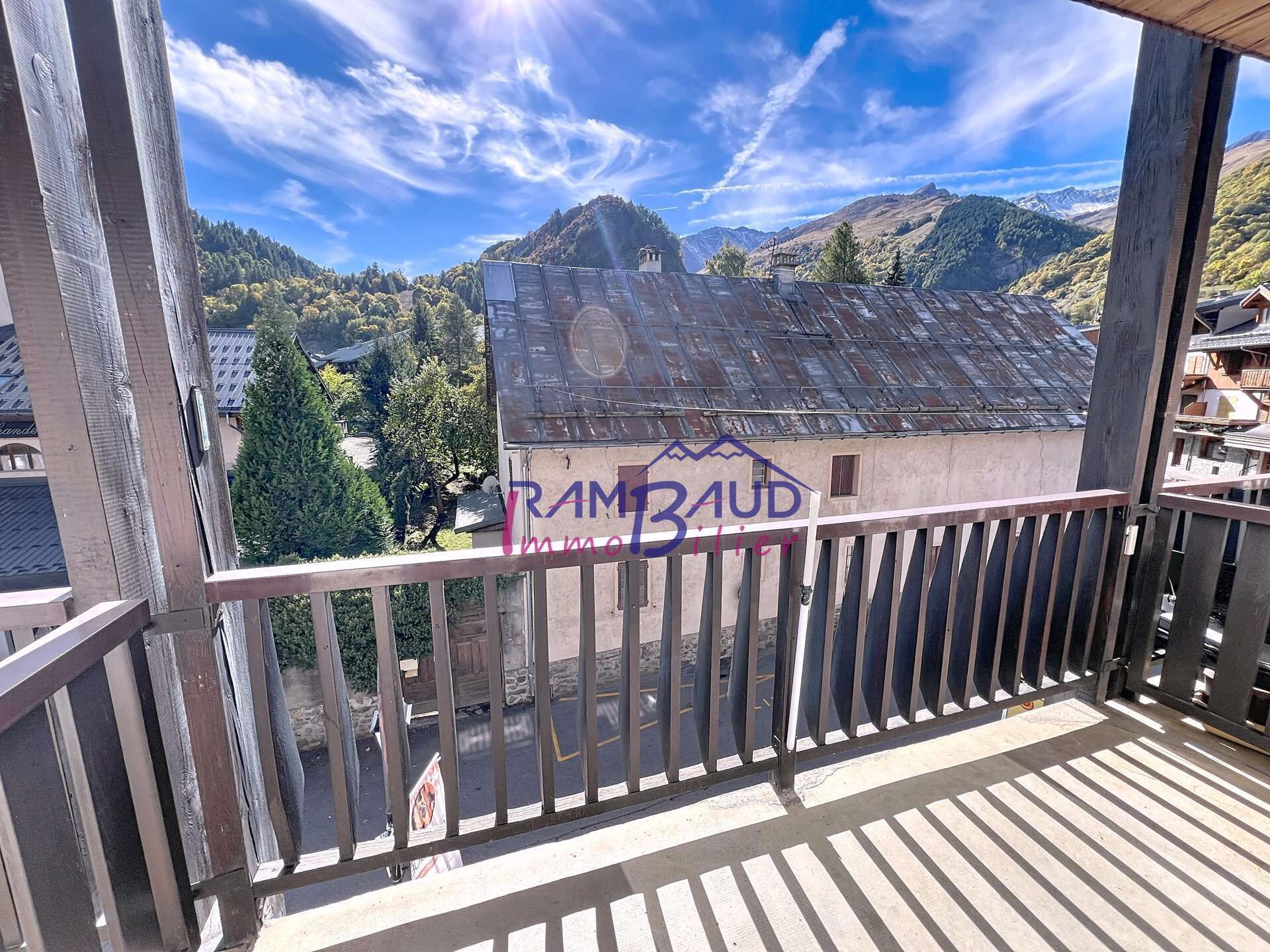 A balcony with a view of a mountain range and a building with graffiti.