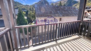 Un balcon donnant sur une chaîne de montagnes et un bâtiment couvert de graffitis.