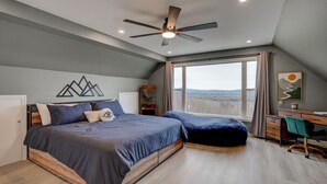 A bedroom with a bed, a desk, and a large window. - Stunning Views | Hot Tub | Pets (Carroll)