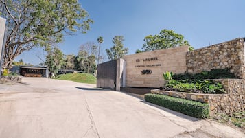 A stone entrance with a sign reading "EL LAUREL EVENTOS - VILLAS - SPA".