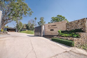 Un ingresso in pietra con un cartello che recita 'EL LAUREL EVENTOS - VILLAS - SPA'.