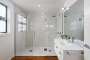 Regadera, tina de hidromasaje, toallas, papel de baño