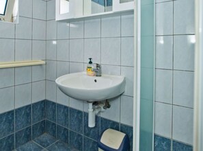 Bathroom features a wall-mounted sink with a soap dispenser and drainage pipe.