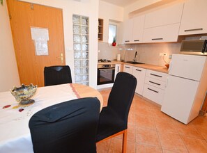 Enjoy meals in this kitchen with a dining area, featuring a stainless steel oven and microwave.