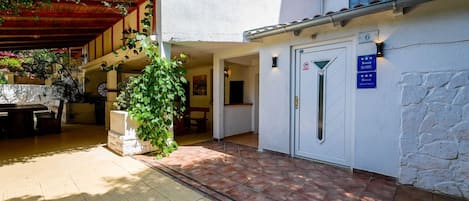 A building with a white exterior, a door marked with a number, and a sign indicating it is a 4-star Sobe apartment.