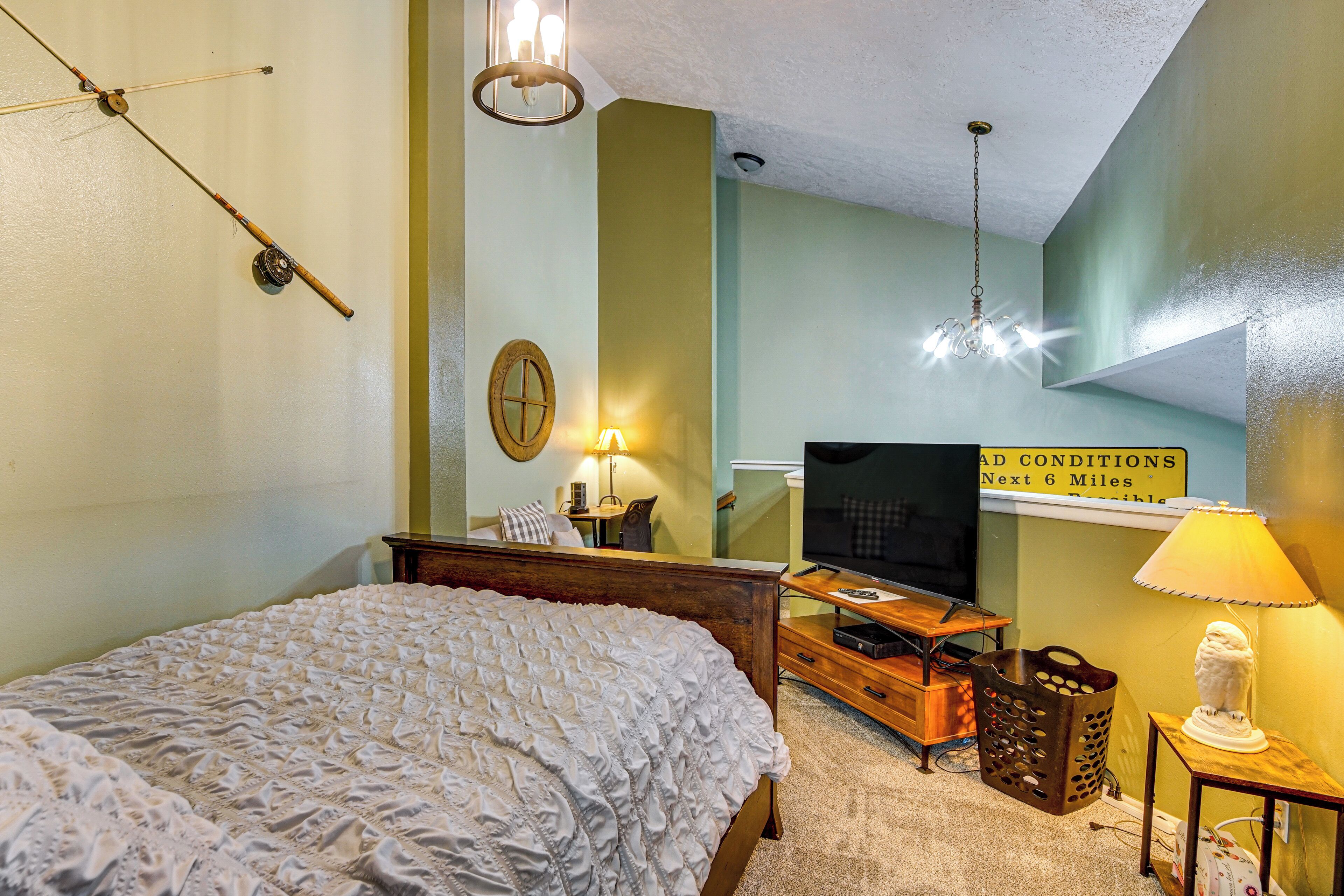 A bedroom with a bed, a television, a lamp, and a sign indicating room conditions.
