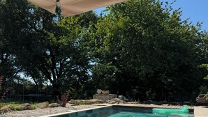 A rectangular swimming pool with clear water, surrounded by a stone deck and a canopy. - Nature-themed vacation rental with a private spa and fully air-conditioned pool (Saint-Astier)