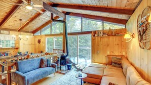 A cozy cabin interior with a wooden interior, a dining area, and a large window providing a view of the outdoors. - 6 Mi to Slopes: Forest-View Haven in West Dover! (West Dover)