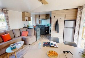 Cozy living space with a kitchenette, sofa, and dining table.