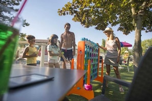 Children can play on the interconnected tubes and platforms in this outdoor play area surrounded by trees.