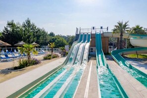 Parque aquático com vários toboáguas e área de piscina com espreguiçadeiras.