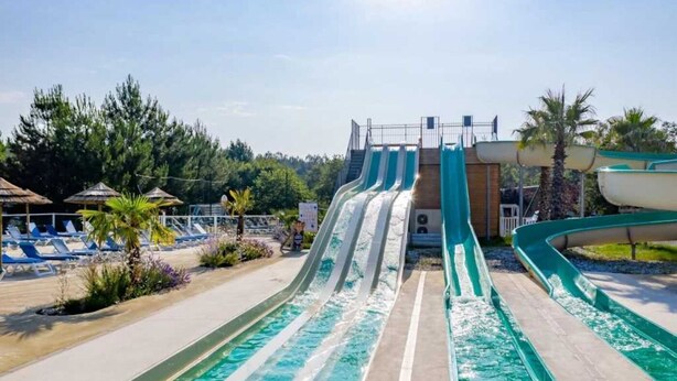 A water park with multiple water slides and a pool area with lounge chairs.