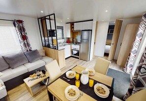 Enjoy a compact living space with a kitchenette, dining area, and comfortable sofa.